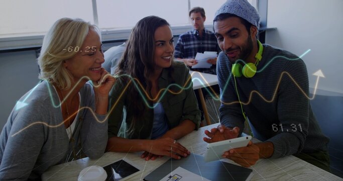 Leaning group of three colleagues sharing ideas at meeting classroom table, with tablet and beanie