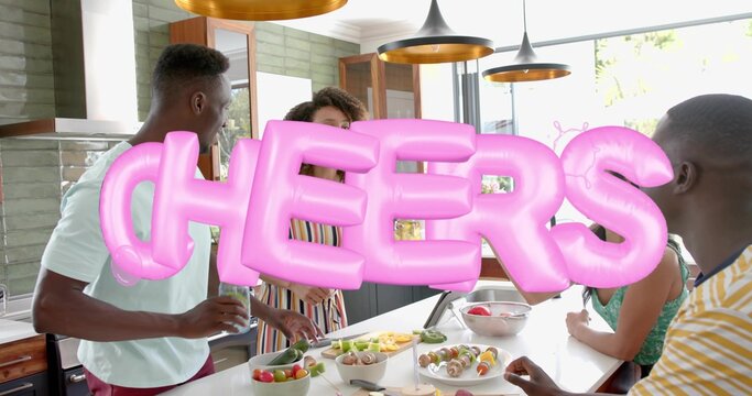 Four adults gathering, preparing skewers at kitchen island with pink CHEERS balloon in casual wear