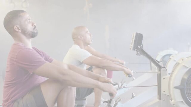 Female on ergometer starting stroke, man matching motion, trio syncing strokes for fitness