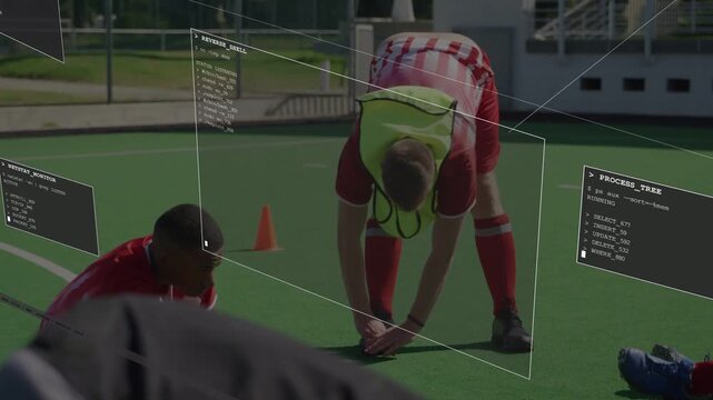 Bibbed player bending, adjusting gear near cone, HUD panels floating, tracking for sports training