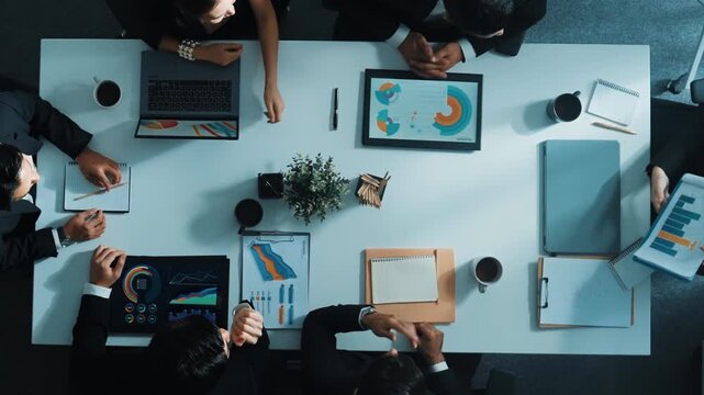 Top down aerial view of diverse business team listening manager present growth sales while giving a high five to encourage or motivate team. Group of people celebrate successful project. Directorate.