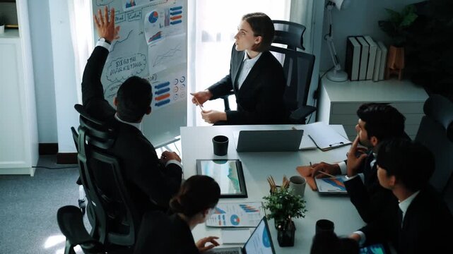 Top view of smart manager compare chart between board and paper while planning startup project with group of diverse team at business meeting. Team brainstorming and working together. Directorate.