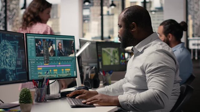 Video editor cutting raw film footage with advanced AI software on PC, working in modern studio office. Creative process shows color grading and motion graphics tools powered by machine learning.