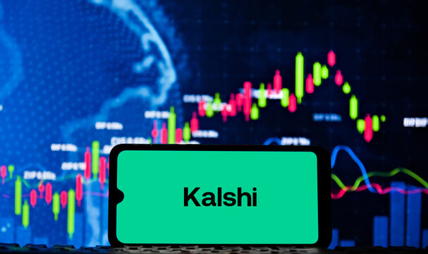 Kalshi logo on a smartphone screen with a stock market chart in the background. Kalshi is a market prediction platform.
