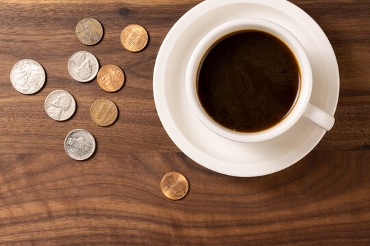 Cup of Coffee on Wooden Surface with Loose Change &ndash; Everyday Expenses Concept