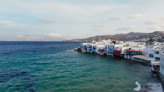 Mykonos island traditional whitewashed homes on the Aegean sea shore, Drone shot