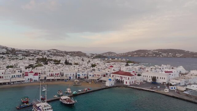 Mykonos island at sunset, seaside luxury Cycladic style villas and whitewashed, cubic houses, Aegean Sea, Paralia, Cyclades, Establishing drone shot