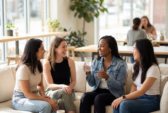 Diverse group of happy young women talking and drinking water