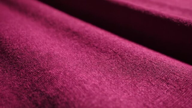 Close up macro view of magenta pink knitted fabric texture with soft focus background.