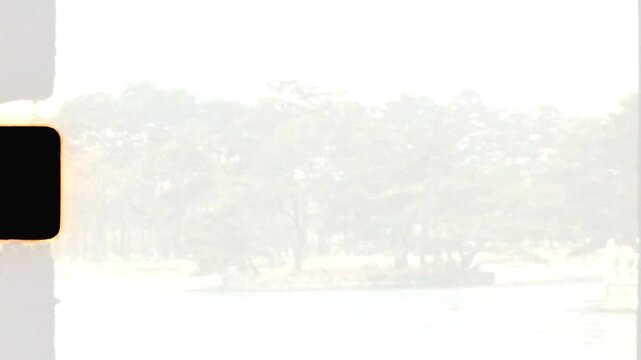 Super 8 mm vintage film of forest trees in the middle of a frozen lake at Hyangwonji Pond near Hyangwonjeong Pavilion temple in Gyeongbokgung Palace Seoul city South Korea Asia nature and tourism