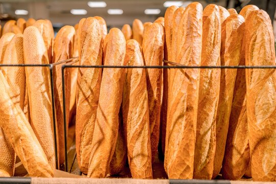 French baguettes displayed upright on a bakery shelf