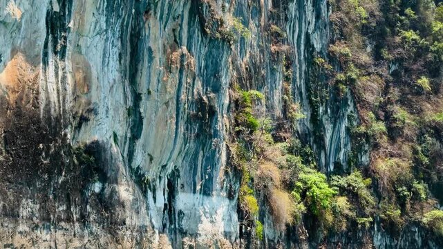 Close-up of massive limestone cliff walls and emerald water at Cheow Lan Lake, reminiscent of the Avatar world. Detailed rock textures and ancient geological formations in Khao Sok, Thailand.