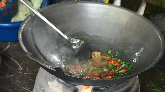 Close-up of cooking spicy Indonesian stir-fried noodles with fresh ingredients in a pan