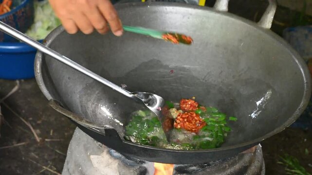 Close-up of cooking spicy Indonesian stir-fried noodles with fresh ingredients in a pan