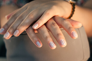 top view of female hands with elegant polka dot nail art manicure © Jonathan