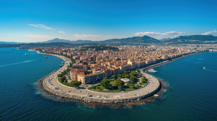 Obraz premium Aerial view of coastal cityscape with curved promenade, waterfront park and distant mountains