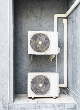 Air compressor cold temperature on wall grey cement building outdoor construction, electric fan power supply technology