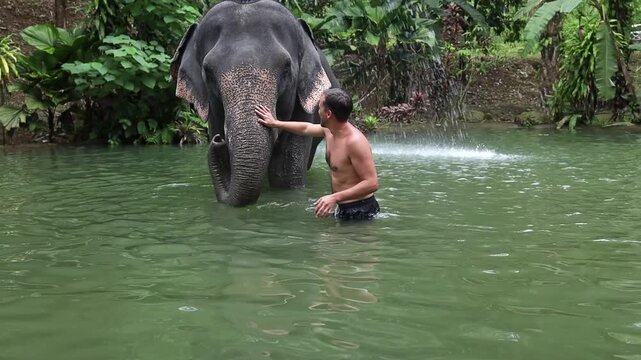 A European man enjoys a swim in a lake with an elephant, highlighting the exoticism and joy of interacting with animals. Adventure tourism, vacation in southern countries.