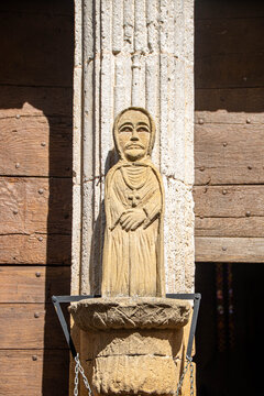 Medieval stone statue of a saint on St Dominique church door in Monpazier