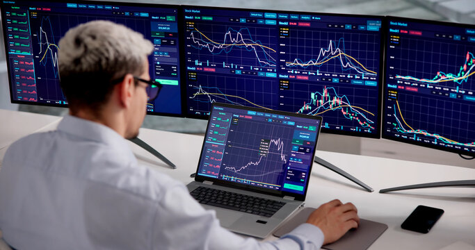 Financial Trader Monitors Multiple Monitors For Market Analysis