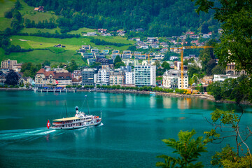 Naklejka premium Vintage Paddle Steamer Sailing on Lake Lucerne with Brunnen Town and Green Alpine Hills | Swiss Flag, Waterfront Buildings and Turquoise Water in Central Switzerland