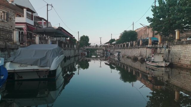 Drone Gliding Low Over Potami Lefkimmis Canal Water Passing Under Stone Bridge in Lefkimmi Greece