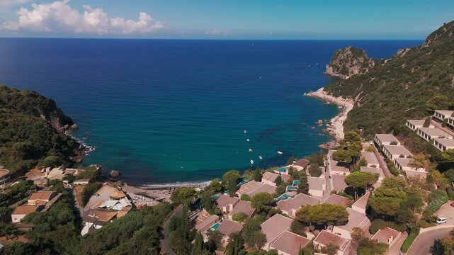 Aerial View Flying Over Ermones Beach Resorts Towards Deep Blue Ionian Sea in Corfu Greece