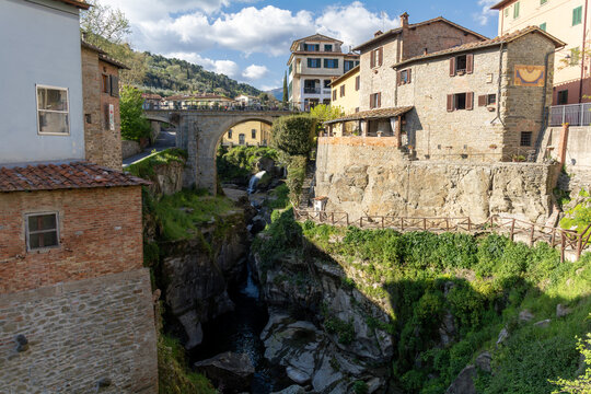 View of the historic stone houses and ancient bridge over the rocky gorge in the medieval village of Loro Ciuffenna, Tuscany, Italy.