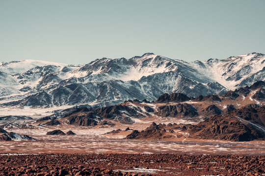 Vast Snow-Capped Peaks Rise Over Rocky Terrain in Southern Mongolia