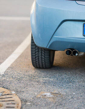 Rear detail of blue Opel Tigra Twintop parked on street.