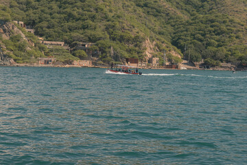 Obraz premium Speed boat transporting tourists exploring coast
