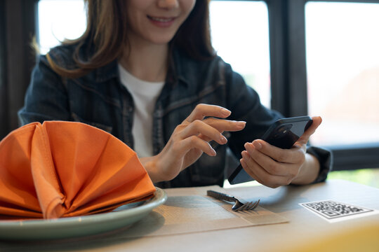 Person scanning the QR code with mobile phone and order foods at the restaurant. 