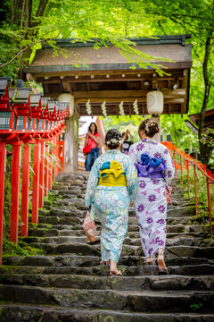 Back view of two women wearing Japanese yukata summer kimono in Kifune Shrine stairs gate, Kyoto, Japan.