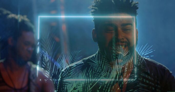 Singing singer wearing patterned shirt, holding mic on stage with neon frame and palm projection