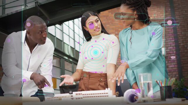 Designers leaning and pointing at scale model, man initiating gesture, AR nodes guiding consensus