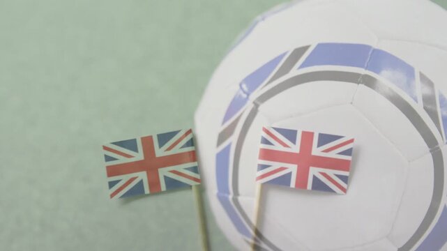 Soccer ball entering from right edge, pressing Union Jack flags, rotating and forming tight layout
