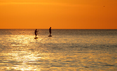 Fototapeta premium Two people are on surfboards in the ocean