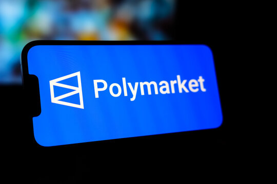 Smartphone Displaying the Polymarket Logo on a Bright Blue Screen, Positioned Horizontally Against a Dark, Blurred Background for a Modern Fintech and Digital Prediction Market Concept.