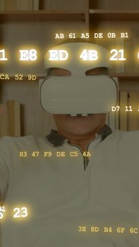 Vertical video: Senior male raising hand and waving by shelf, headset getting hex codes showing VR