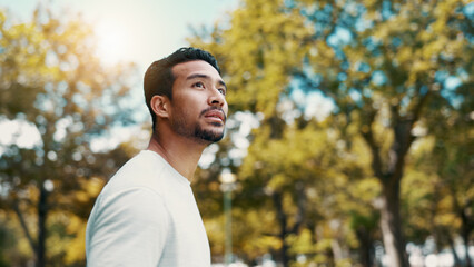 Runner, man and thinking of fitness at park, serious and rest after workout and training in morning. Outdoor, athlete and person in nature post exercise, space and cool down on break and low angle © peopleimages.com