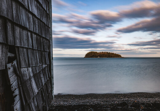weathered siding next to ocean with island in distance, Maine