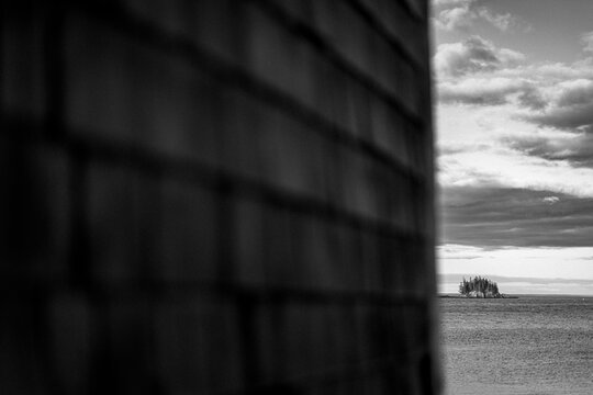 Tiny island along Maine coast seen from behind shingled wall