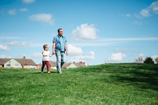 Father with his daughter walking in the park, parenthood and education