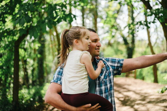 Father and daughter walking together on a woodland path