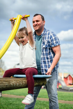 Father and daughter at playground, summer time