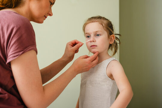 Mother applying soothing gel to child&rsquo;s rash in natural home setting