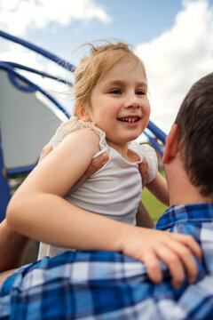 Father holding his daughter at playground