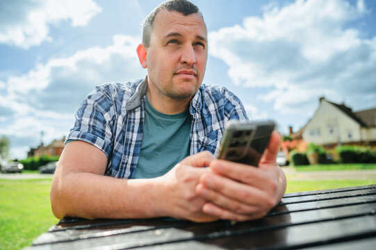 Man using smartphone, outdoors portrait