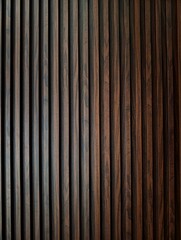 Obraz premium Dark wooden slats arranged vertically on a modern interior wall, featuring a rich brown and black textured grain pattern for minimalist architectural backgrounds.