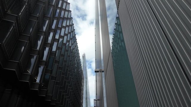 Low angle dolly shot revealing skyscrapers in london's financial district, representing business, economy, and corporate architecture on a cloudy day in the united kingdom